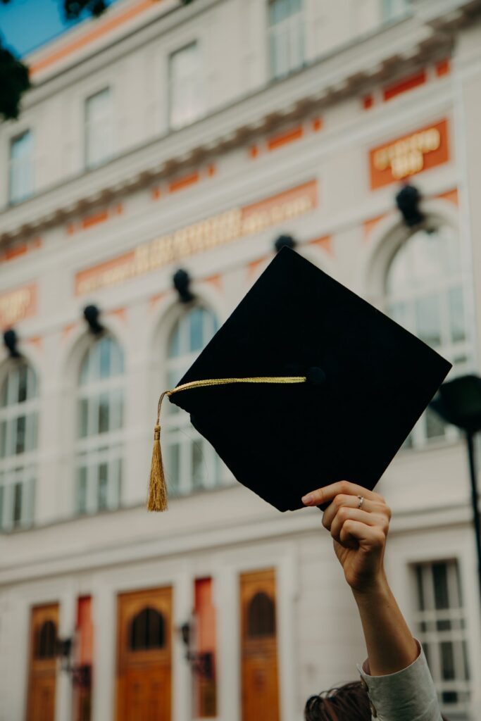 Graduating student holding a cap in celebration